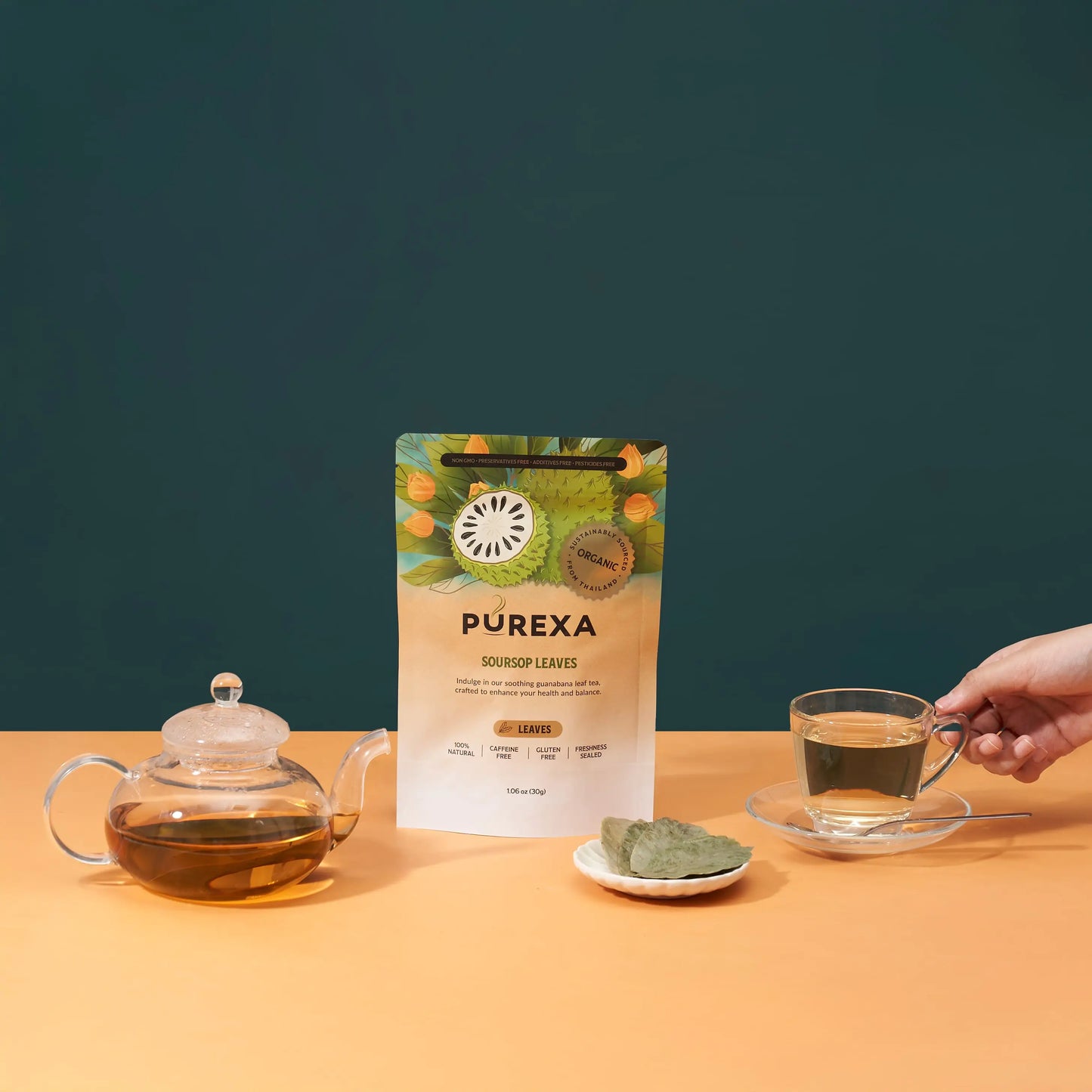 PUREXA soursop whole leaves pouch between a glass teapot and a prepared cup of herbal tea
